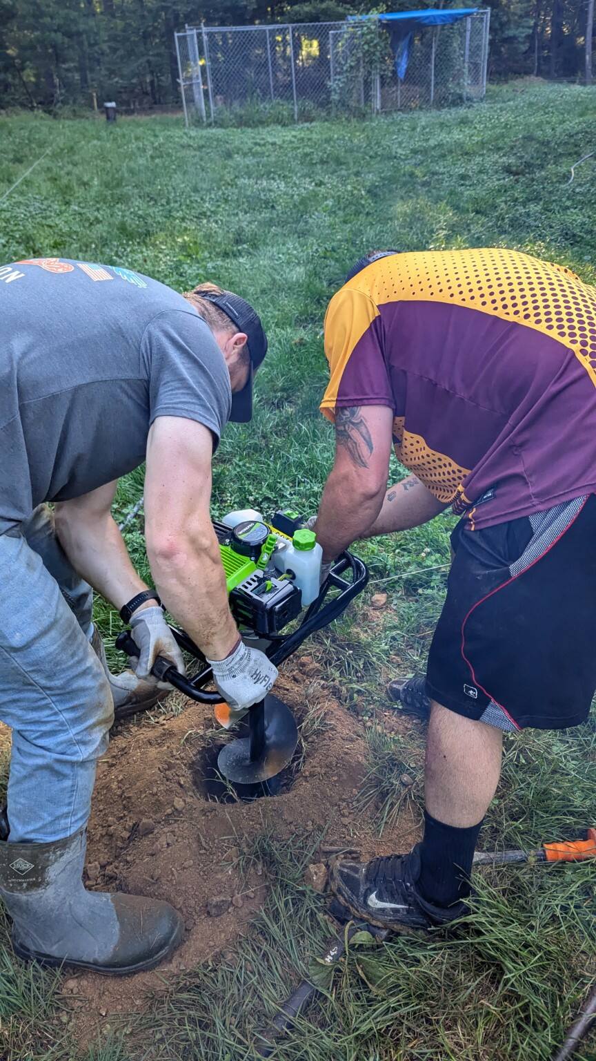 Pitboss crew using an auger to prepare a fence post hole